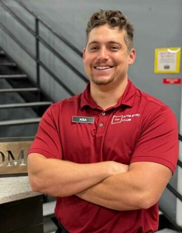 man with arms crossed in red polo inside a fitness gym in Marble Falls, TX