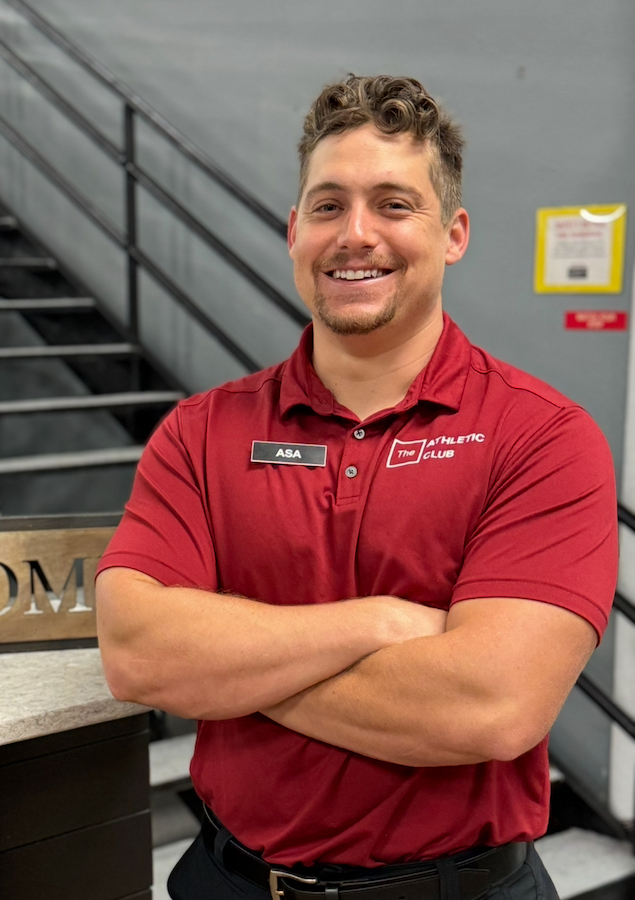 man with arms crossed in red polo inside a fitness gym in Marble Falls, TX