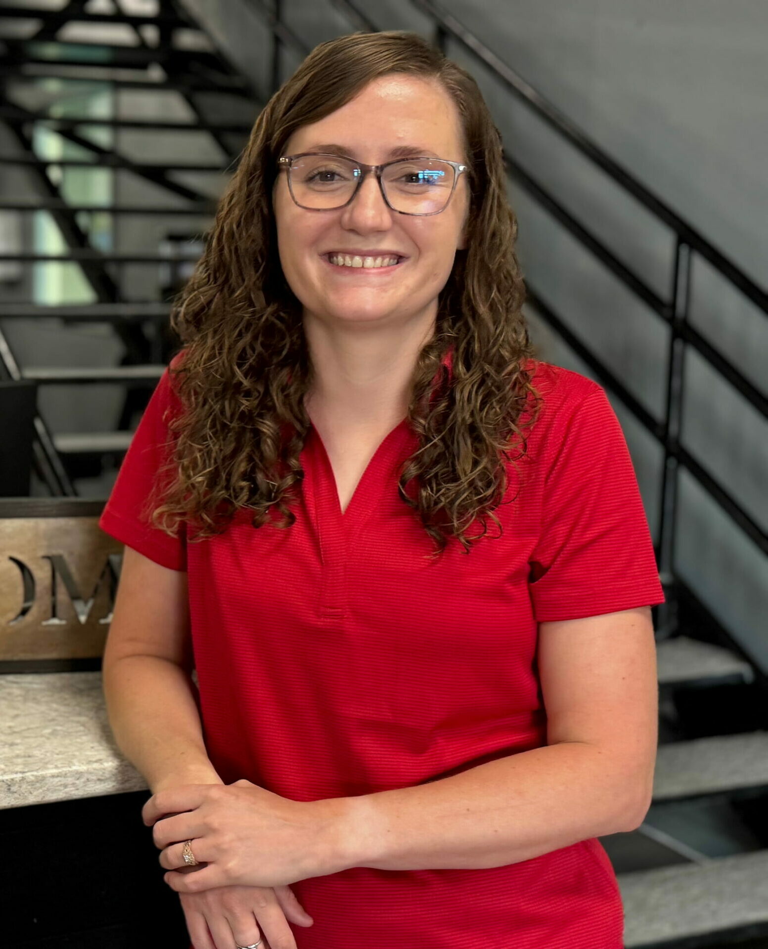 woman smiling in red polo inside a fitness gym in Marble Falls, TX